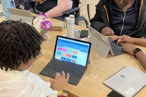 A man holds and ipad and a woman points at it